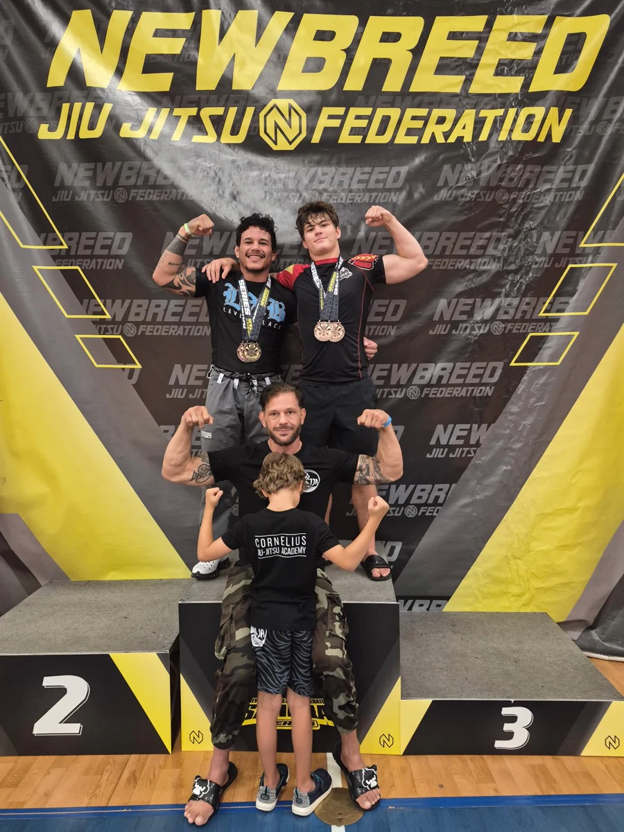 A group posing with medals at a NEWBREED jiu-jitsu tournament