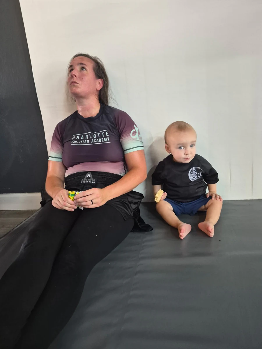 An adult and a small child taking a snack break beside the mats
